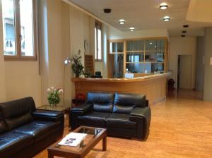 um átrio com sofás de couro preto e uma sala de espera em Ospitalità San Tommaso d'Aquino em Bolonha