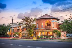 a large brick building with a balcony on a street at Aquarius Backpackers Resort in Byron Bay