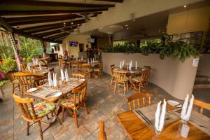 an empty restaurant with wooden tables and chairs at Club del Mar Oceanfront in Jacó