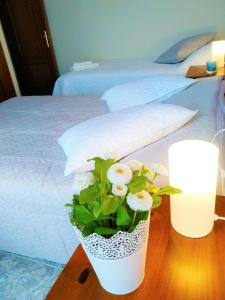 a vase of flowers on a table next to a bed at Bright spacious apartment, 2 min walk from beach in Candelaria