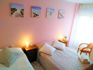 a bedroom with two beds and two candles on the wall at Bright spacious apartment, 2 min walk from beach in Candelaria