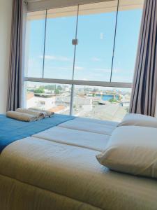 uma cama grande num quarto com uma janela grande em Sky S House em São Paulo