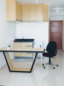 een keuken met een bureau en een zwarte stoel bij Sky S House in Sao Paulo