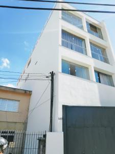 een wit gebouw met een poort ervoor bij Sky S House in Sao Paulo