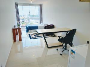 um quarto com uma secretária, uma cama e uma cadeira em Sky S House em São Paulo