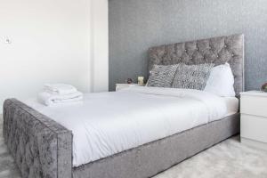 1 dormitorio con 1 cama grande y cabecero gris en Incredible 3BR Battersea Flat & Spectacular View, en Londres