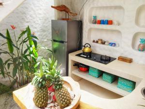 a kitchen with two pineapples on a table next to a refrigerator at Villa Rustic Charm in Gili Trawangan