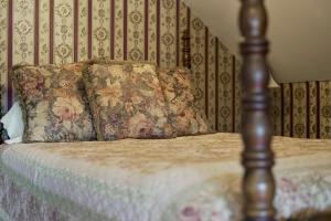 a bed with two pillows on top of it at Prairie Creek Inn in Walton
