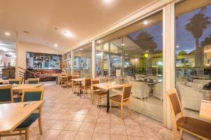 un restaurante con mesas, sillas y ventanas en Copthorne Hotel & Resort Bay Of Islands en Paihia