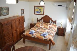 Un dormitorio con una cama y una cómoda de madera. en Delta House, en Salta