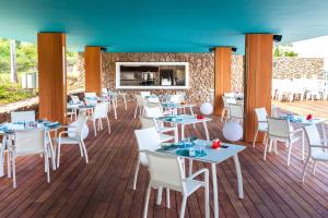 a restaurant with tables and chairs on a deck at Te Moana Tahiti Resort in Punaauia