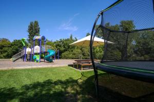 - un parc avec une aire de jeux dotée d'un toboggan et d'un parasol dans l'établissement BIG4 Wangaratta North Cedars Holiday Park, à Wangaratta