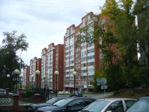 トムスクにあるУчебная 8の高層ビルの前に車を駐車した駐車場