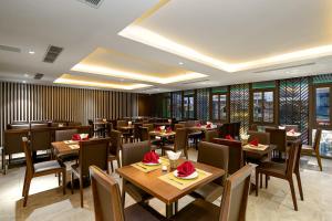 a restaurant with tables and chairs in a room at Palazzo 3 Danang Hotel in Da Nang