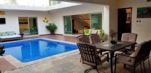 a living room with a pool and a table and chairs at Suites Lagunas in Colima