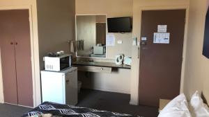 Pokój ten wyposażony jest w biurko i kuchenkę mikrofalową. w obiekcie Aquatic Motor Inn w mieście Taree