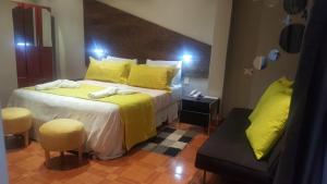 ein Schlafzimmer mit einem Bett mit gelber Bettwäsche und gelben Kissen in der Unterkunft Hotel Iris in Salta