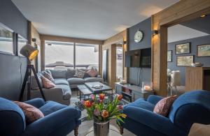 a living room with blue couches and a table with flowers at Phoenix 101 in Tignes