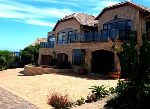 a large brick house with a large driveway at Golf & Tides in Mossel Bay