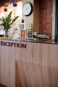 a reception desk with a clock on the wall at The Grand Campbell Hotel Kuala Lumpur in Kuala Lumpur