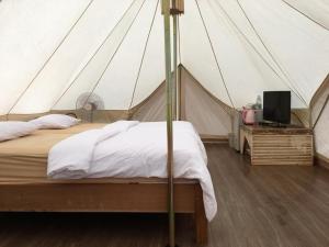 ランタ島にあるLanta Local Hutのテント内のベッド1台が備わるベッドルーム1室