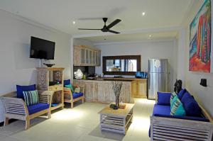 a living room with blue furniture and a kitchen at Lembongan Sanctuary Villas in Nusa Lembongan