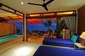 sala de estar con sofá y vistas al océano en Lembongan Sanctuary Villas, en Nusa Lembongan