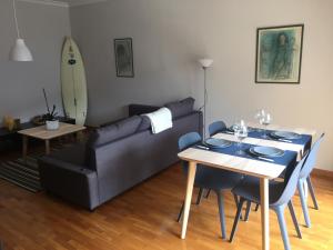 uma sala de estar com um sofá e uma mesa com cadeiras em Oporto Beach appartement em Matosinhos