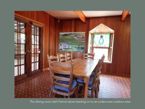 a dining room with french doors leading out to an outdoor kitchen at Chapel Hill Winery Guest House in McLaren Vale