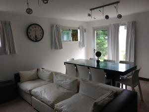 a living room with a couch and a table and a clock at Almejas 20 Pinamar - a mts del Mar in Pinamar