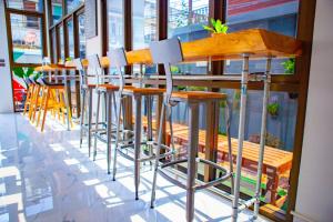 a row of stools in front of a bar at Rich8 Hostel in Bangkok