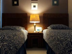 sypialnia z 2 łóżkami i lampką na stoliku nocnym w obiekcie Playasol Las Hadas w mieście Manzanillo