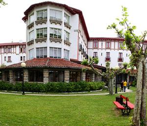 萊昆韋里的住宿－阿耶斯塔蘭一號旅館，前面有红色长凳的大建筑