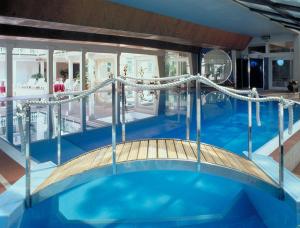 a large swimming pool with a rope bridge at Hotel Biondi in Montecatini Terme