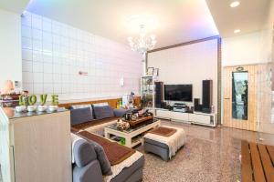 a living room with a couch and a tv at Miao Fu Homestay in Xiaoliuqiu