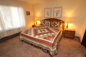 a bedroom with a bed and two lamps and a window at Discovery 4 #128, Loft in Mammoth Lakes +6 photos