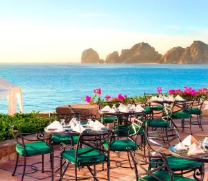 a patio area with tables, chairs and umbrellas at Pueblo Bonito Rose Resort & Spa - All Inclusive in Cabo San Lucas