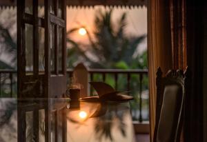 a glass table with a candle and a cup on it at SaffronStays Salt Rim on the Beach, Korlai in Christpāda