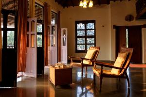 a living room with a table and chairs and windows at SaffronStays Salt Rim on the Beach, Korlai in Christpāda