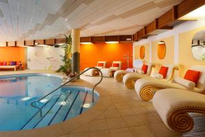 een hotelkamer met een zwembad en stoelen bij Panorama Hotel Nocturnes in Naturno