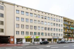 un grande edificio bianco con le auto parcheggiate di fronte di Studio Tamka by BookingHost a Varsavia