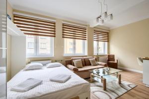 una camera da letto con un letto, un divano e finestre di Studio Tamka by BookingHost a Varsavia