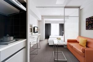 a living room with a couch and a bedroom at Citadines Shinjuku Tokyo in Tokyo