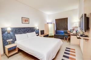 Habitación de hotel con cama y escritorio en Radha Hometel, en Bangalore