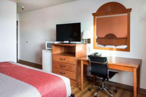a hotel room with a bedroom with a desk and a bed at Motel 6-Wilsonville, OR - Portland in Wilsonville