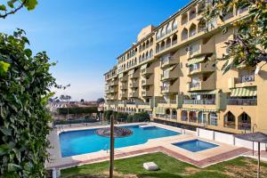 an apartment building with a swimming pool in front of it at Del Parque Flats - Torrevigia in Cala del Moral