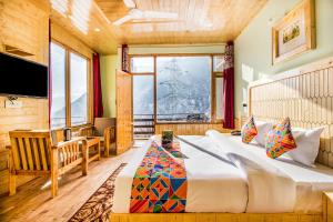 a bedroom with a large bed and a large window at FabExpress Shami Inn Naggar Road in Manāli