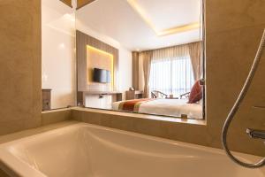 un bagno con vasca e una camera da letto di Landmark Kathmandu a Kathmandu