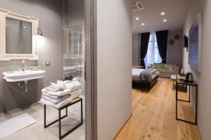 een badkamer met een wastafel en een kamer met een bed bij Il Duomo Luxury Suite in Pietrasanta