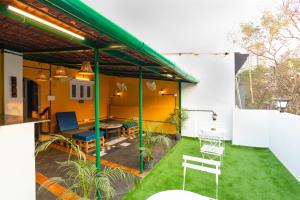 a patio with a green roof with a table and chairs at Hostel Mantra in Mumbai